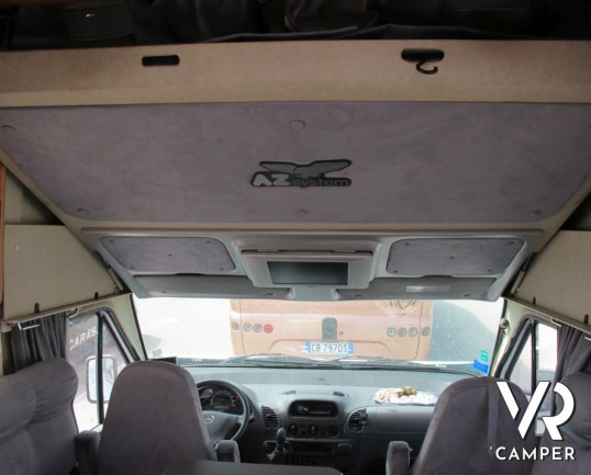 AZ System - maxi motorhome di colore azzurro costruito su misura con ampio garage posteriore, bagno doccia separata e grande dinette.