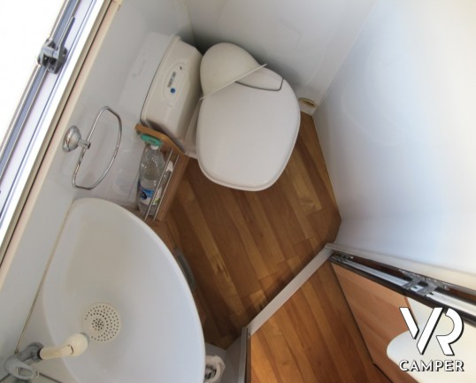 AZ System - maxi motorhome di colore azzurro costruito su misura con ampio garage posteriore, bagno doccia separata e grande dinette.