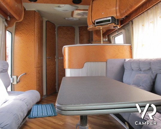 AZ System - maxi motorhome di colore azzurro costruito su misura con ampio garage posteriore, bagno doccia separata e grande dinette.