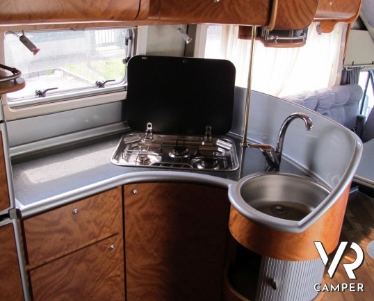 AZ System - maxi motorhome di colore azzurro costruito su misura con ampio garage posteriore, bagno doccia separata e grande dinette.