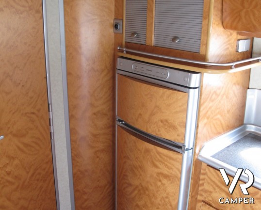 AZ System - maxi motorhome di colore azzurro costruito su misura con ampio garage posteriore, bagno doccia separata e grande dinette.
