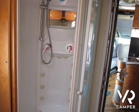 AZ System - maxi motorhome di colore azzurro costruito su misura con ampio garage posteriore, bagno doccia separata e grande dinette.