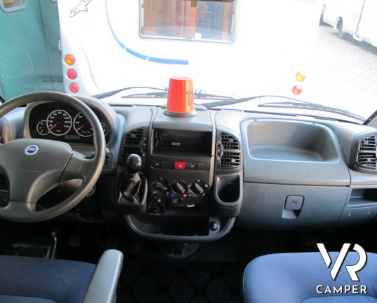 Adria Coral 630: camper mansardato usato con letti a castello posteriori, bagno con doccia separata e dinette classica.