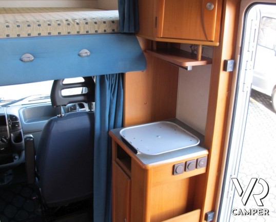 Adria Coral 630: camper mansardato usato con letti a castello posteriori, bagno con doccia separata e dinette classica.