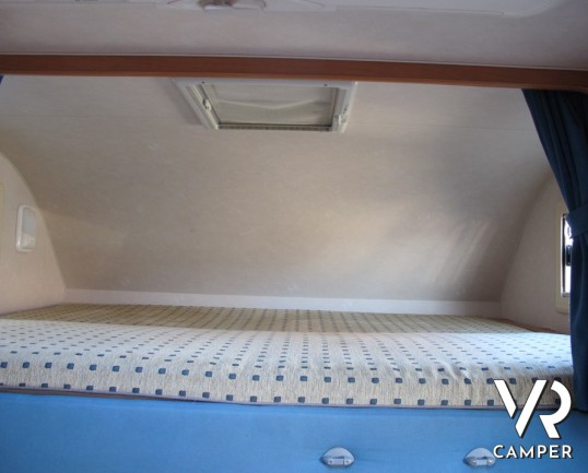 Adria Coral 630: camper mansardato usato con letti a castello posteriori, bagno con doccia separata e dinette classica.