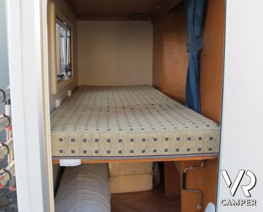 Adria Coral 630: camper mansardato usato con letti a castello posteriori, bagno con doccia separata e dinette classica.