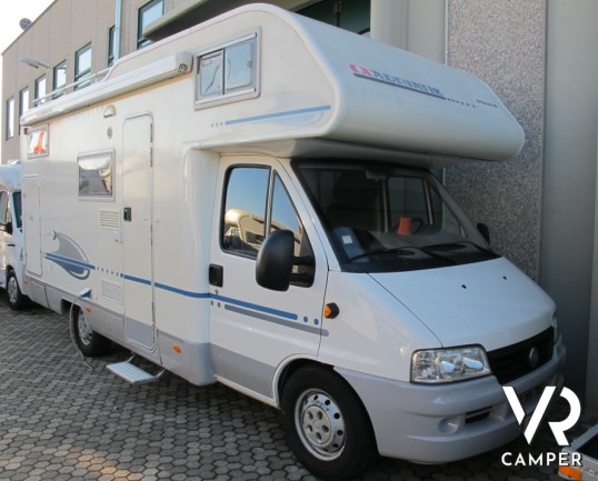 Adria Coral 630: camper mansardato usato con letti a castello posteriori, bagno con doccia separata e dinette classica.