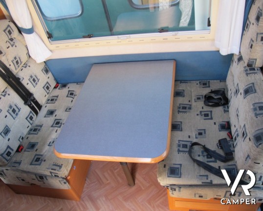 Adria Coral 630: camper mansardato usato con letti a castello posteriori, bagno con doccia separata e dinette classica.