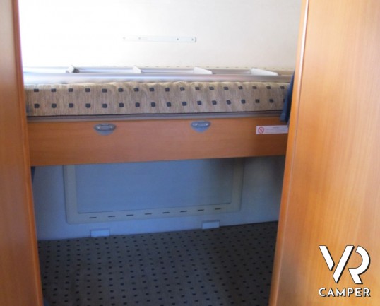 Adria Coral 630: camper mansardato usato con letti a castello posteriori, bagno con doccia separata e dinette classica.