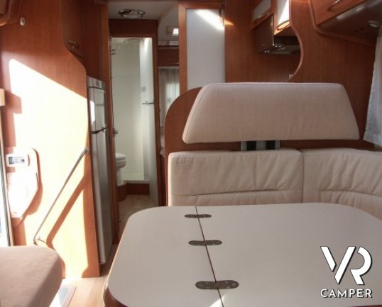 Arca P 674: camper usato semintegrale con letto alla francese posteriore, ampia cucina e dinette, frigorifero grande e portamoto, in ottime condizioni