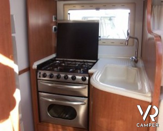 Arca P 674: camper usato semintegrale con letto alla francese posteriore, ampia cucina e dinette, frigorifero grande e portamoto, in ottime condizioni