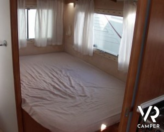 Arca P 674: camper usato semintegrale con letto alla francese posteriore, ampia cucina e dinette, frigorifero grande e portamoto, in ottime condizioni