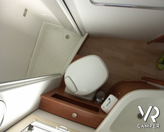 Arca P 674: camper usato semintegrale con letto alla francese posteriore, ampia cucina e dinette, frigorifero grande e portamoto, in ottime condizioni