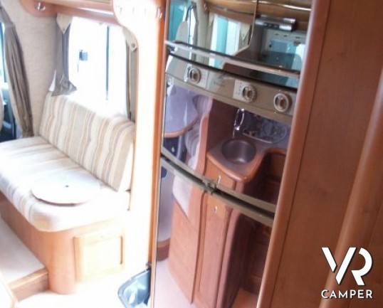 Rapido 7097F: camper semintegrale usato con letto matrimoniale in coda e ampio garage, bagno e doccia separata, dinette grande con divano frontale.