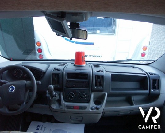 Rapido 7097F: camper semintegrale usato con letto matrimoniale in coda e ampio garage, bagno e doccia separata, dinette grande con divano frontale.