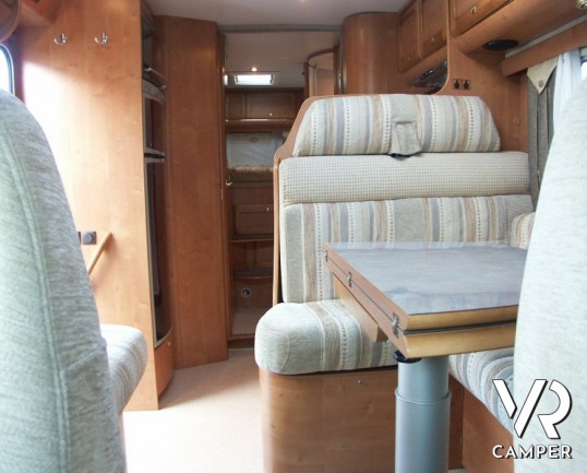 Rapido 7097F: camper semintegrale usato con letto matrimoniale in coda e ampio garage, bagno e doccia separata, dinette grande con divano frontale.