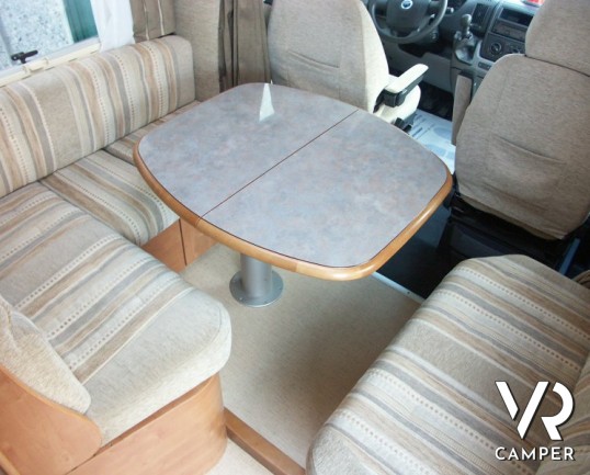 Rapido 7097F: camper semintegrale usato con letto matrimoniale in coda e ampio garage, bagno e doccia separata, dinette grande con divano frontale.