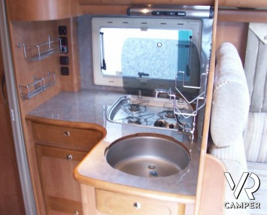 Rapido 7097F: camper semintegrale usato con letto matrimoniale in coda e ampio garage, bagno e doccia separata, dinette grande con divano frontale.