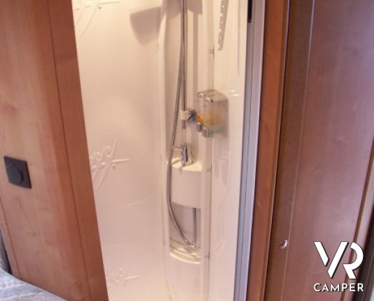 Rapido 7097F: camper semintegrale usato con letto matrimoniale in coda e ampio garage, bagno e doccia separata, dinette grande con divano frontale.