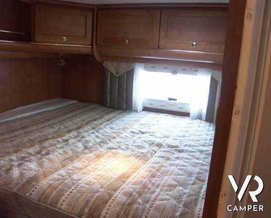 Rapido 7097F: camper semintegrale usato con letto matrimoniale in coda e ampio garage, bagno e doccia separata, dinette grande con divano frontale.