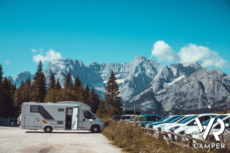 Camper RV semi-integrated in a park with mountains in the background
