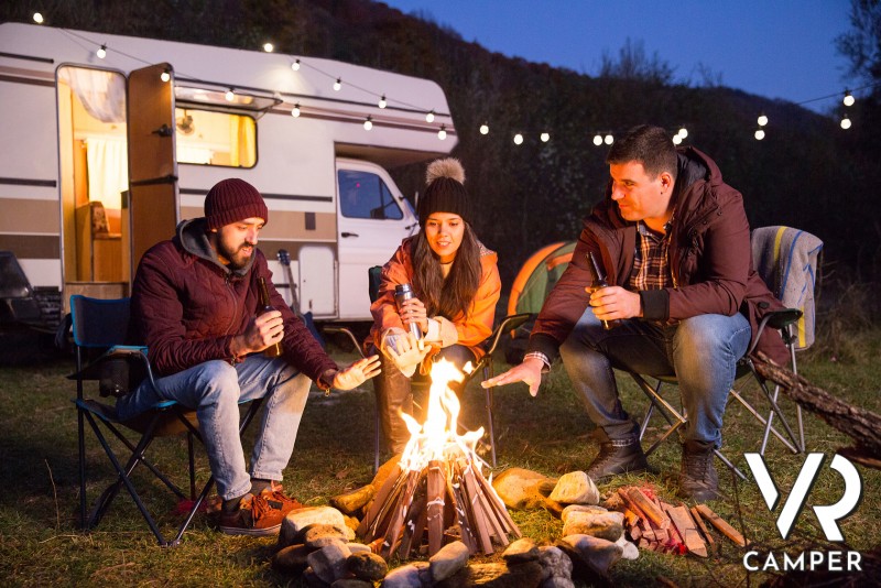 gruppo di amici con falò davanti al camper