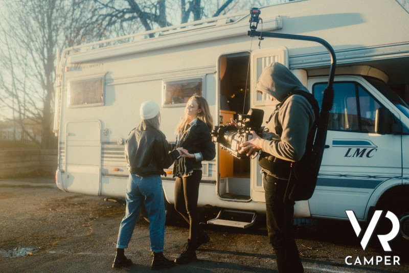 tre amici con videocamera girano un video davanti al camper