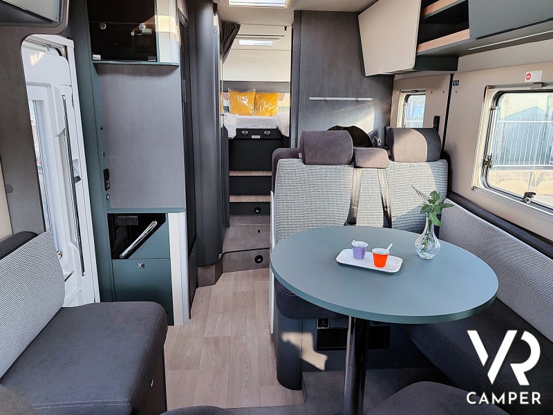 Laika Kosmo H 1409, camper motorhome a noleggio da VR Camper a Torino - Druento. Vista degli interni con dinette e tavolo rotondo.