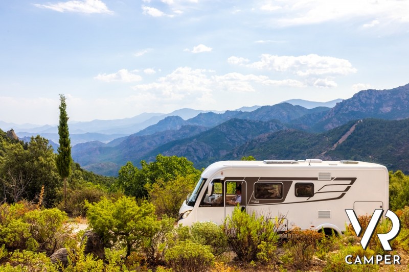 camper motorhome in paesaggio con montagne sullo sfondo