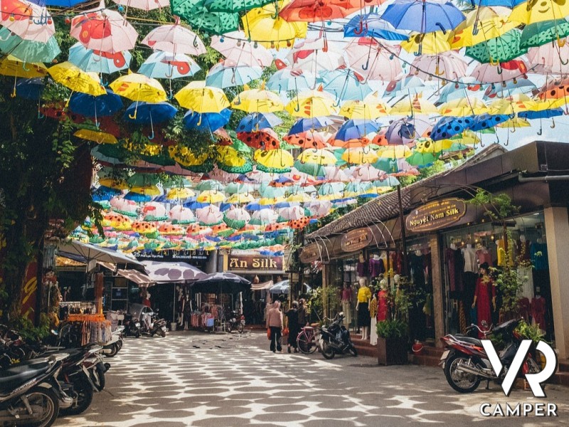 centro storico con locali e negozietti, con ombrelli colorati sospesi