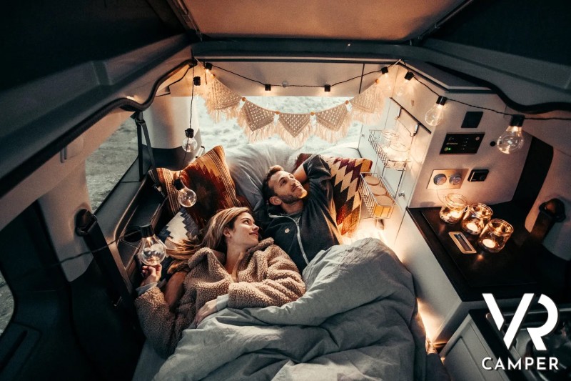Coppia sdraiata sul letto del Crosscamp con lucine notturne accese