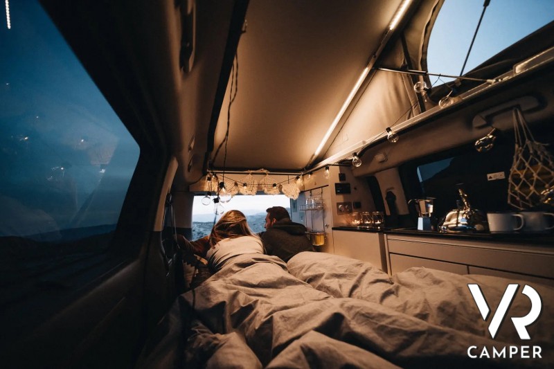 Coppia sdraiata sul letto del Crosscamp guarda il paesaggio serale
