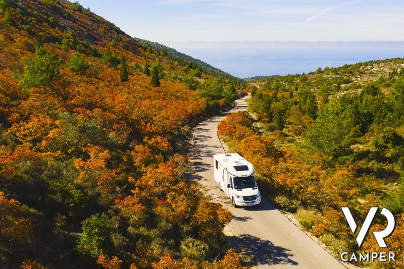 camper su strada tra i boschi in autunno - destinazioni ideali da vedere in camper in autunno