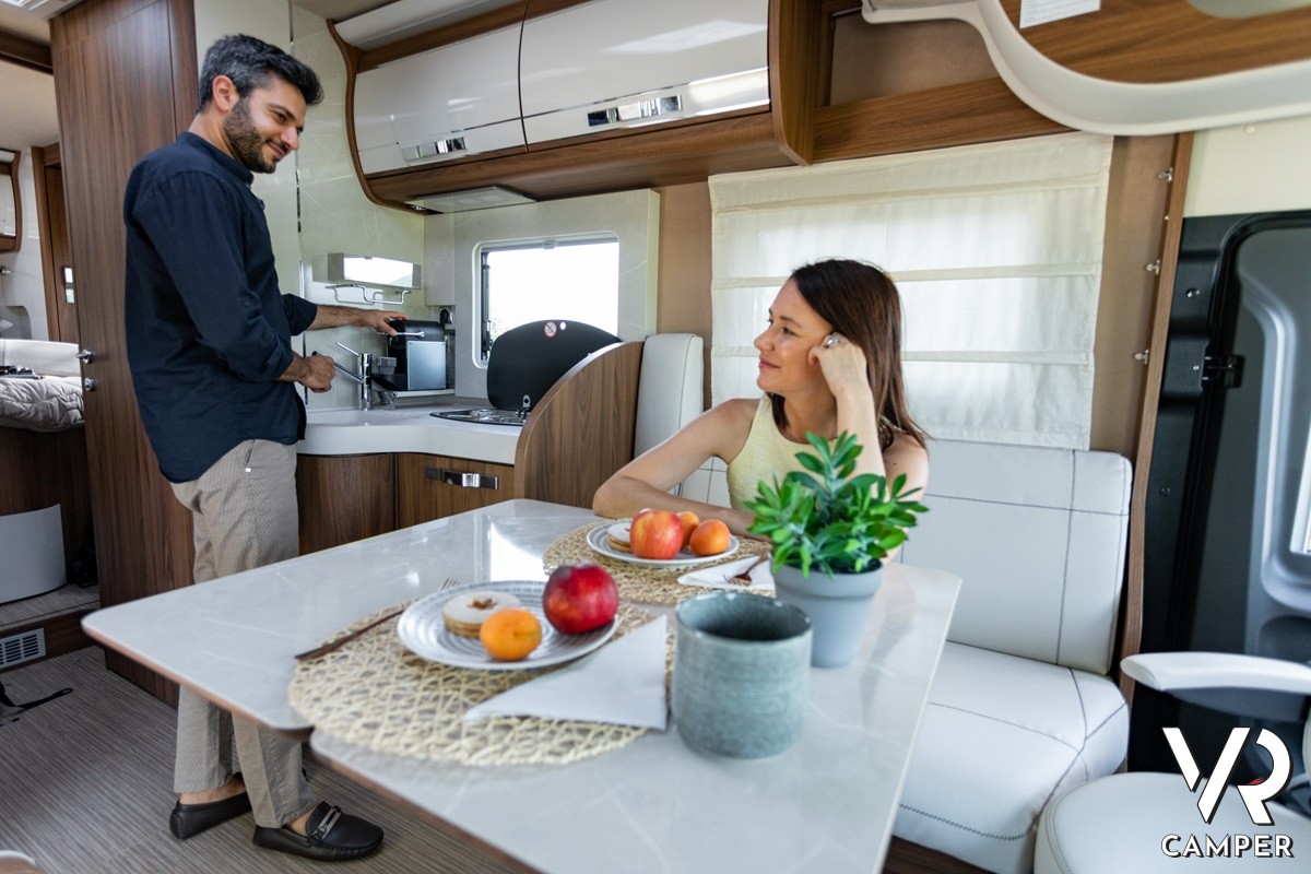 Coppia che fa colazione al tavolo della dinette sul camper