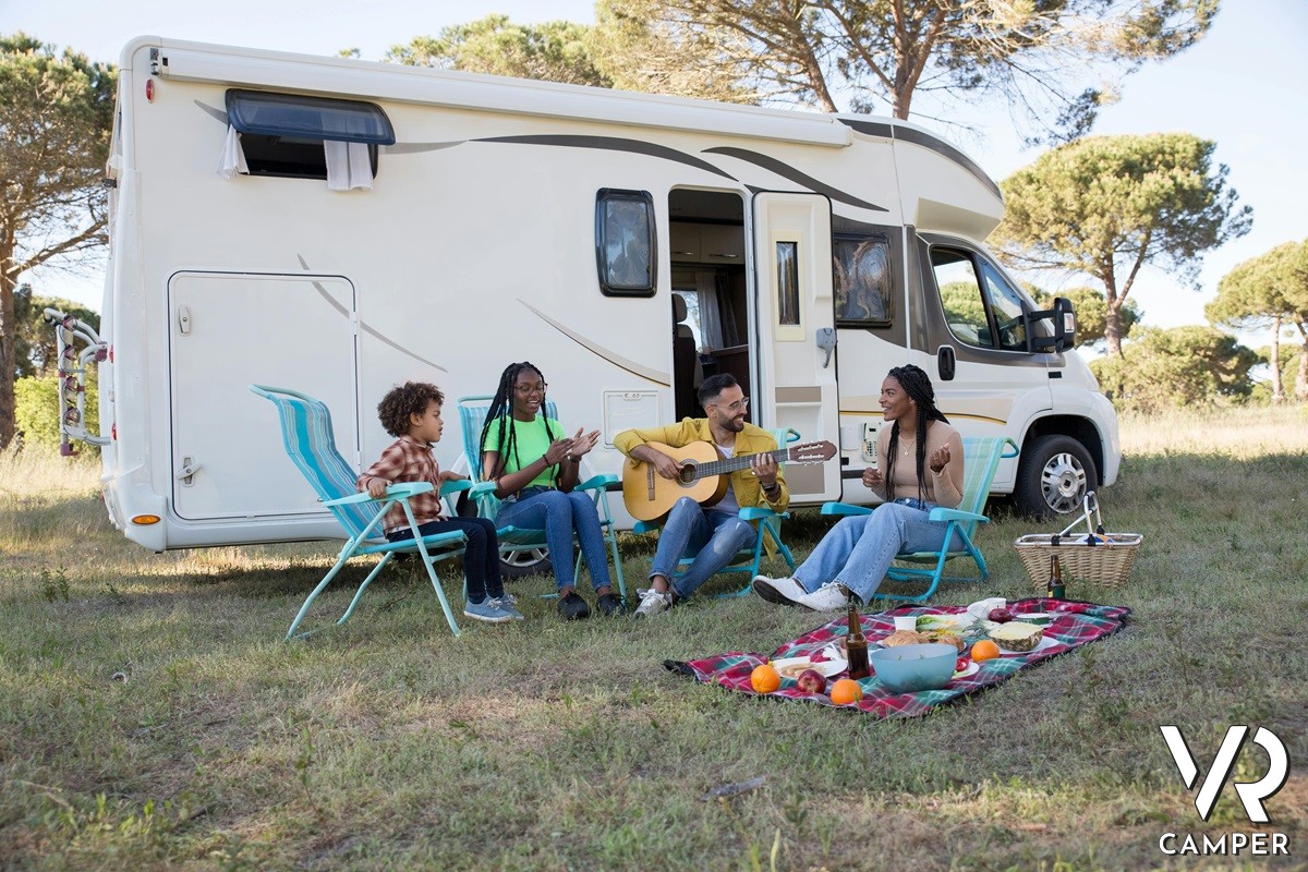 gruppo di amici seduti in cerchio davanti ad un camper nel prato