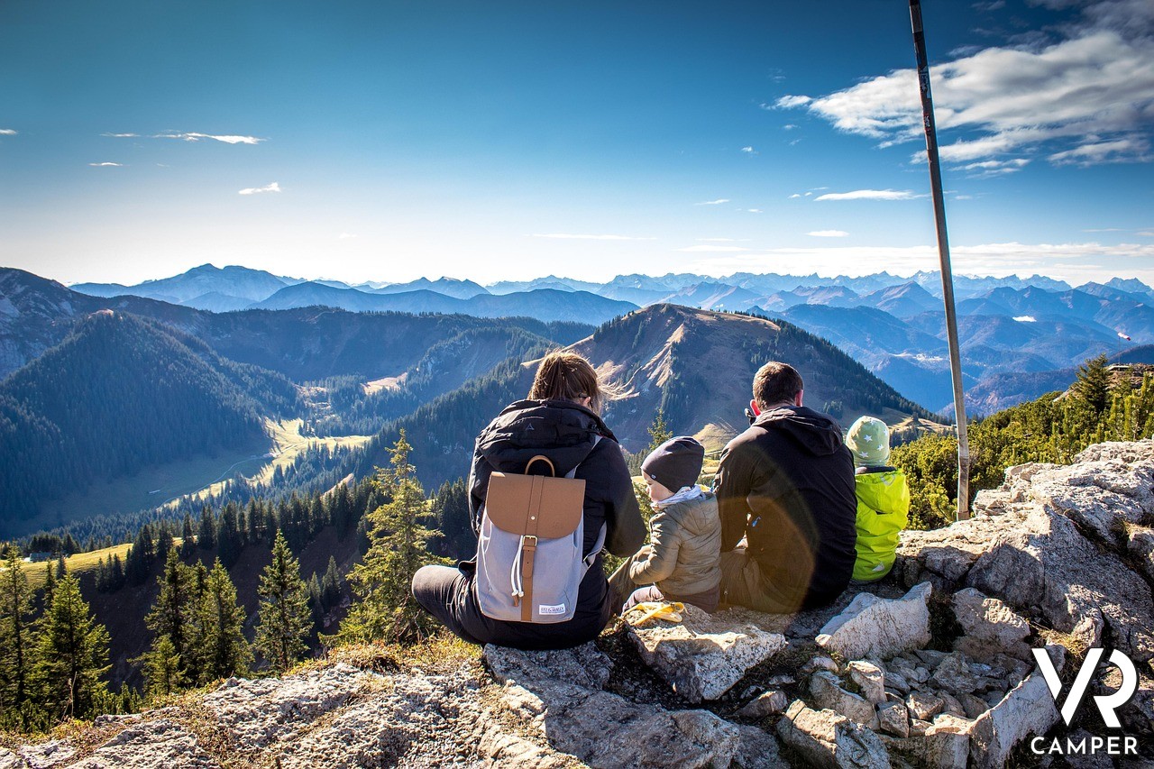 Famiglia seduta di fronte a panorama di montagna